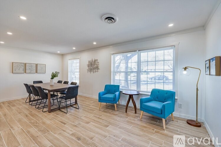 A room with a dining table and chairs.