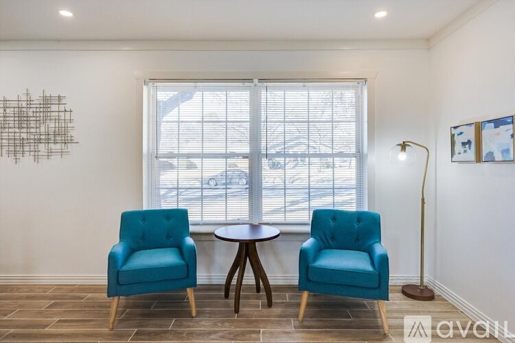 A room with a table, two chairs and a lamp.