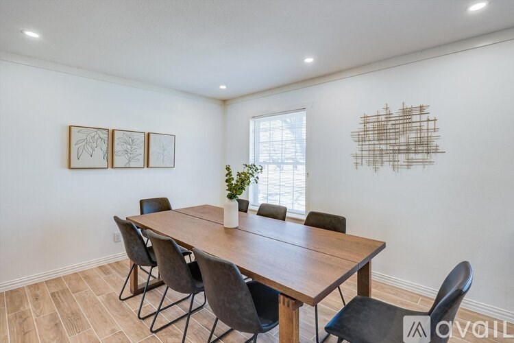 A dining room with a wooden table and chairs.