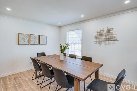 A dining room with a wooden table and chairs.