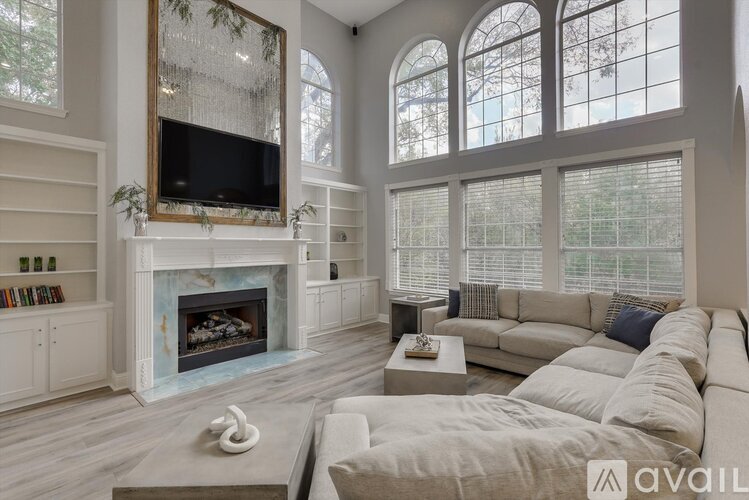 A living room with a fireplace and a television on the wall.