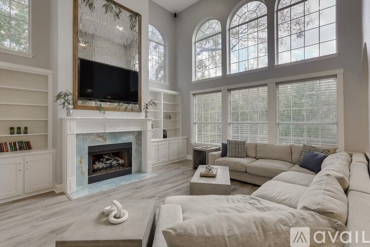 A living room with a fireplace and a television on the wall.