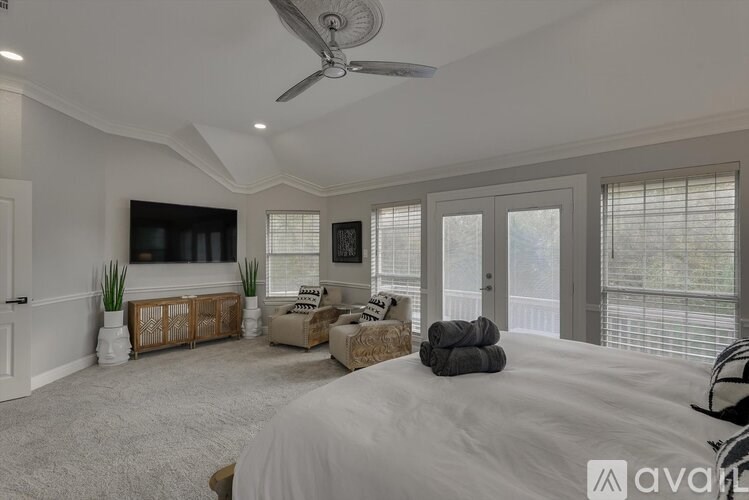 A bedroom with a large bed and a flat screen TV.