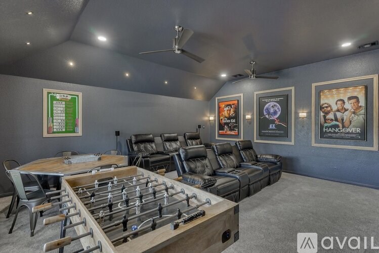 A room with a foosball table and a couch.
