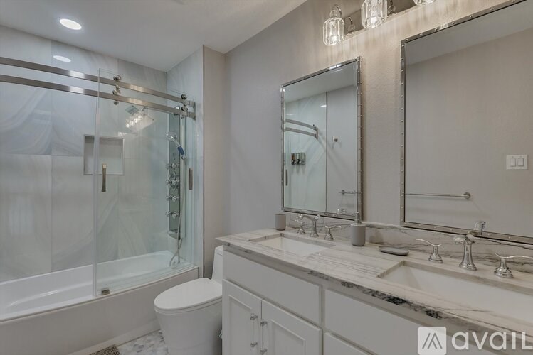 A modern bathroom with a marble countertop and a walk-in shower.