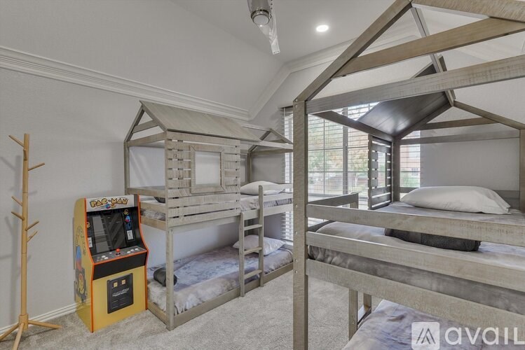 A room with bunk beds and a small arcade machine.