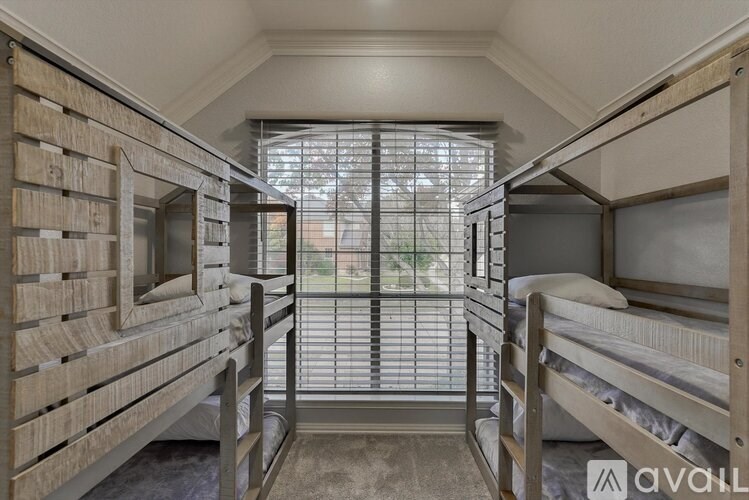 A room with bunk beds and a window with blinds.