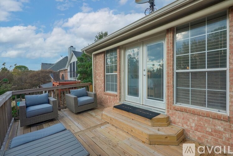 A patio with a table and chairs is in front of a house.