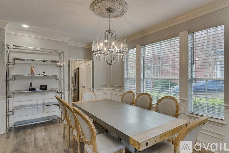 A dining room with a wooden table and chairs.