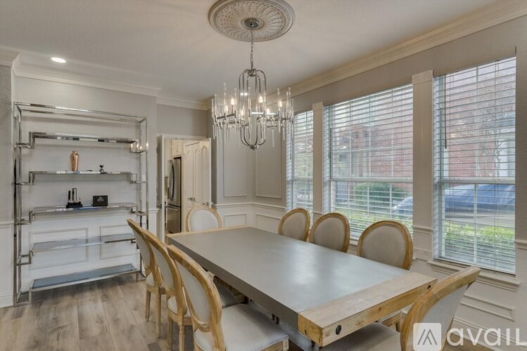 A dining room with a wooden table and chairs.