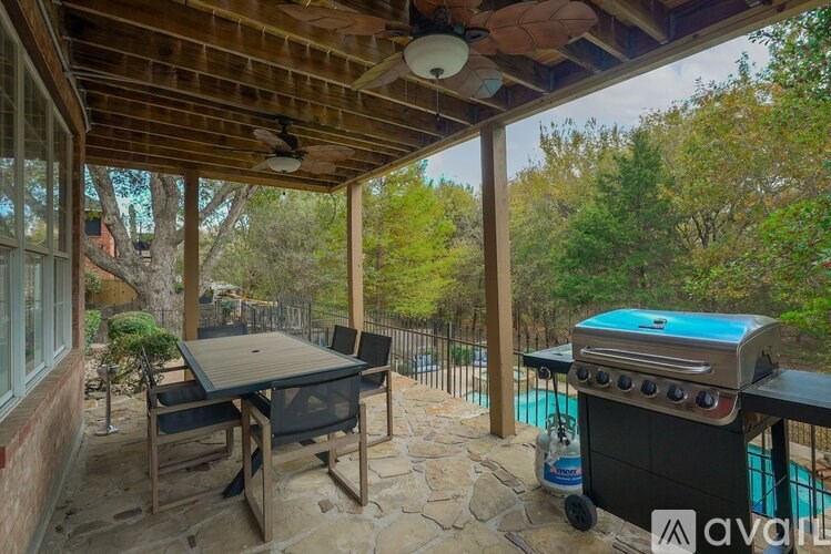 A patio with a grill and a table.