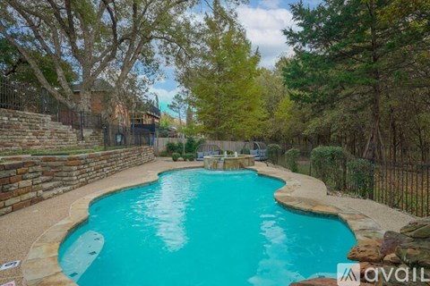 A small pool surrounded by a fence and trees.