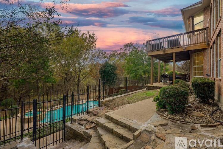 A house with a pool surrounded by a black fence.