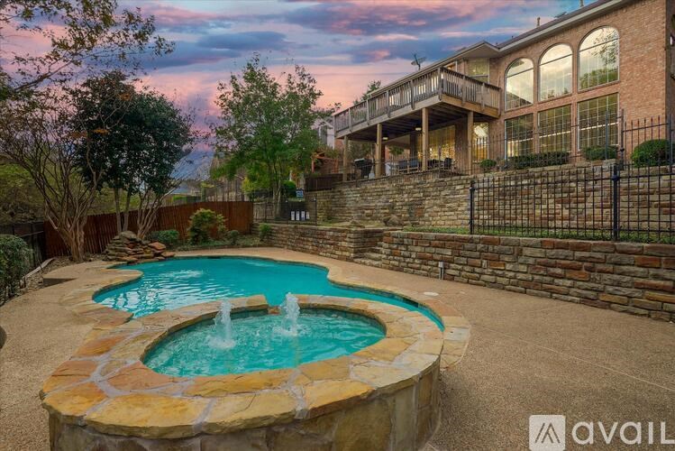 A backyard with a pool and a house in the background.