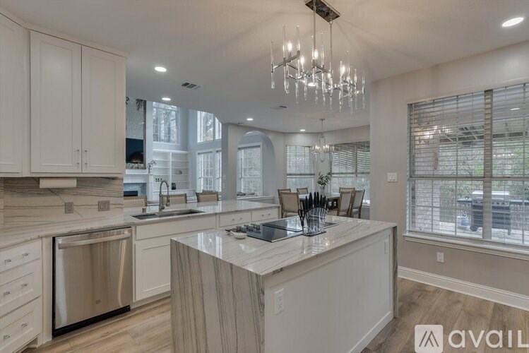 A modern kitchen with a marble island and stainless steel appliances.