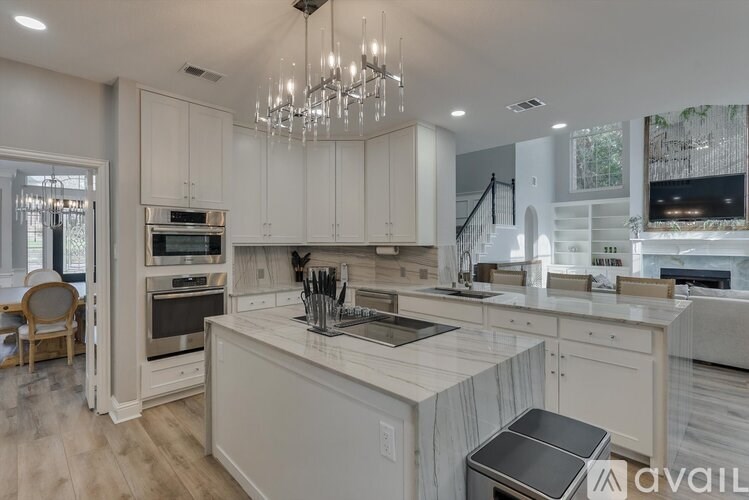 A modern kitchen with a center island and a chandelier.