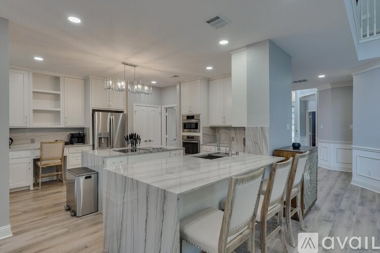 A modern kitchen with a center island and a dining area.