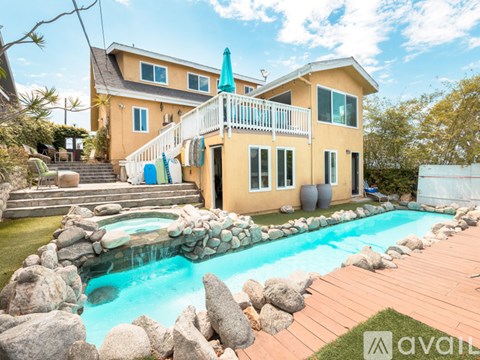 A house with a pool in front of it.