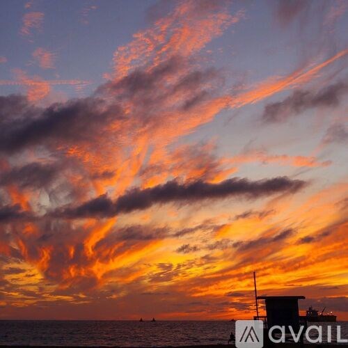 A beautiful sunset with a boat in the foreground.