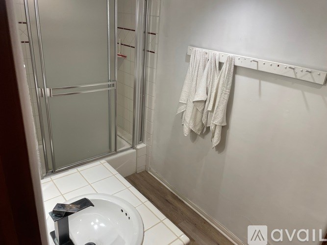 A white towel is hanging on a towel rack in a bathroom.