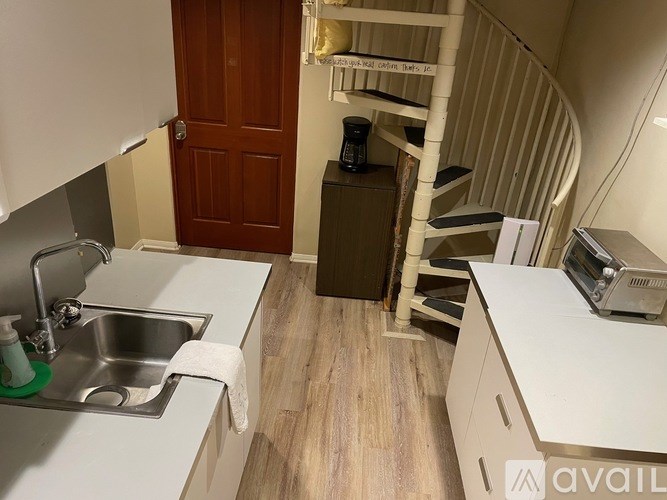 A kitchen with a sink, a towel, and a stove top oven.