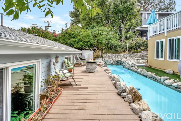 A backyard with a pool and a deck.