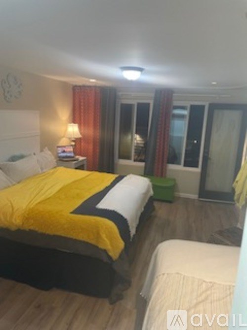 A bedroom with a bed covered in a yellow and black comforter.