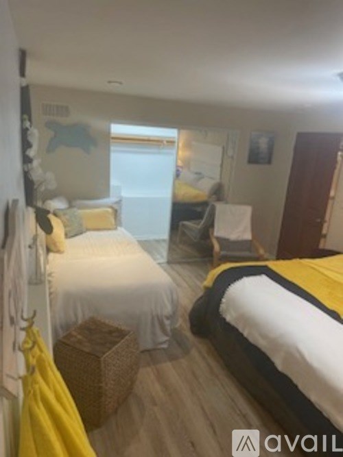 A bedroom with two beds and a chair.