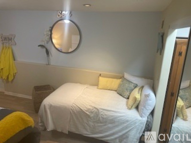 A bedroom with a white bed and yellow pillows.