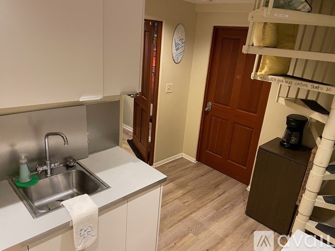 A kitchen with a sink and a clock on the wall.