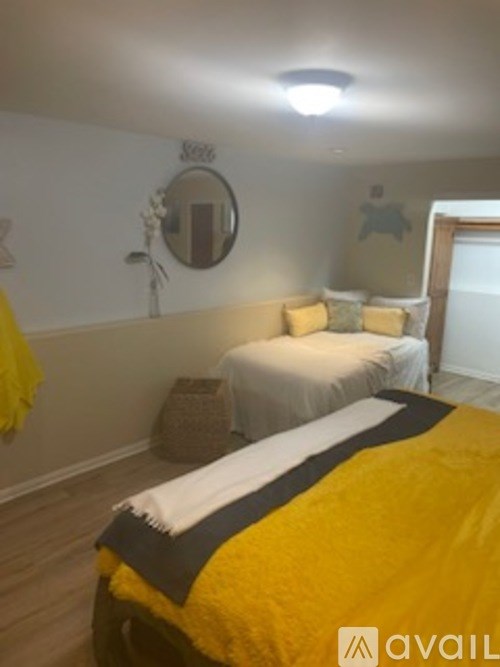 A bedroom with a bed covered in a yellow and black blanket.