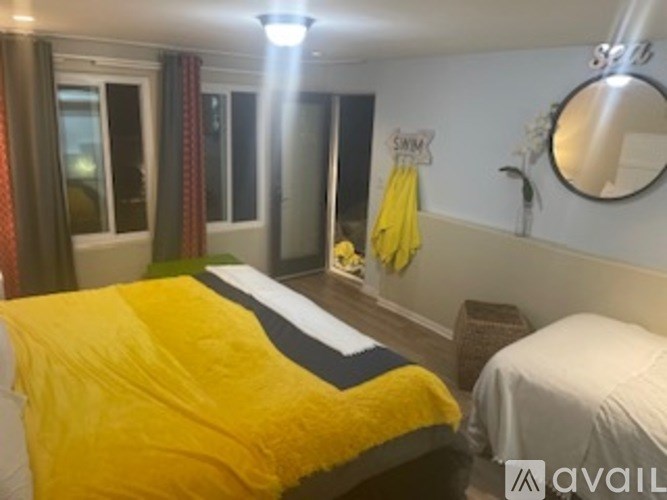 A bedroom with a yellow bedspread and a white bed.