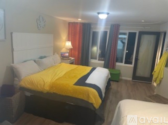 A bedroom with a bed covered in a yellow and white comforter.