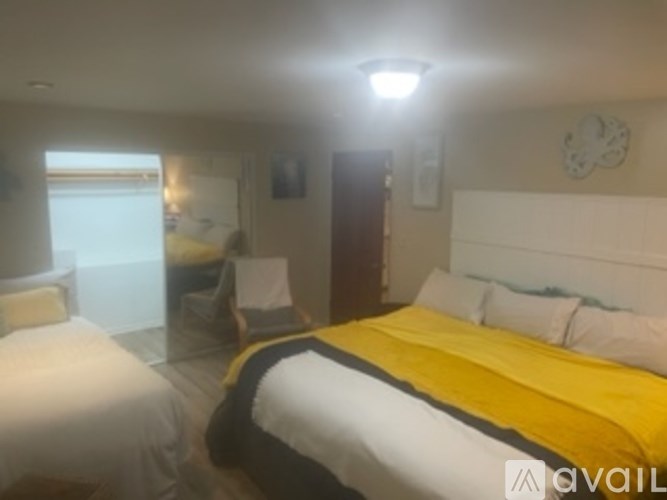 A bedroom with two beds and a clock on the wall.