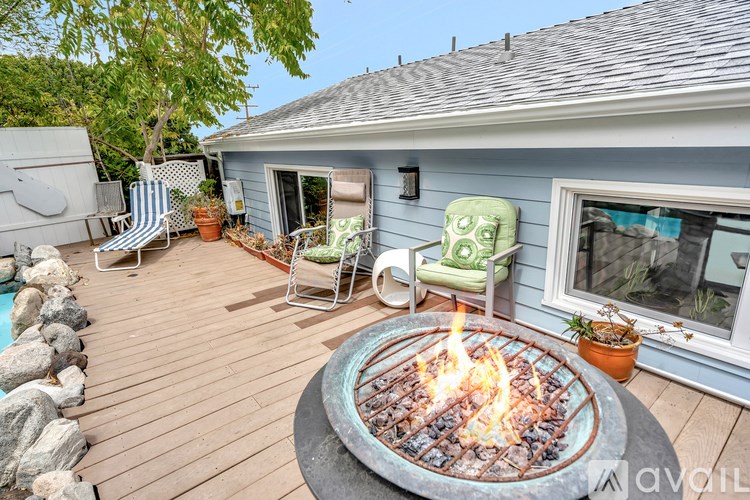 A fire pit is in the middle of a wooden deck.