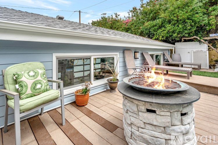 A patio with a grill and a chair.