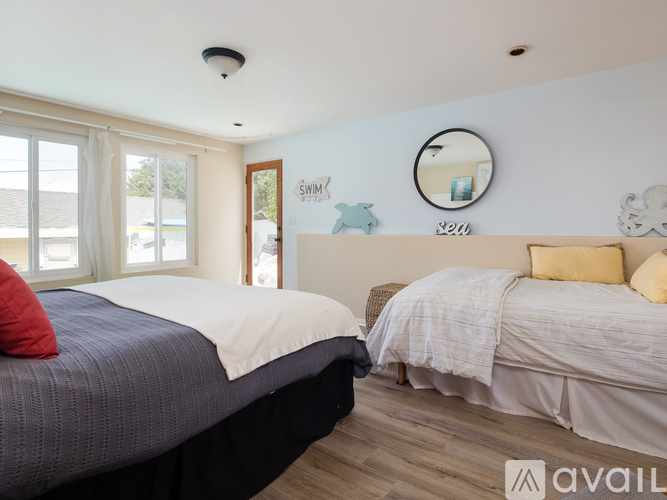 A bedroom with two beds and a mirror on the wall.