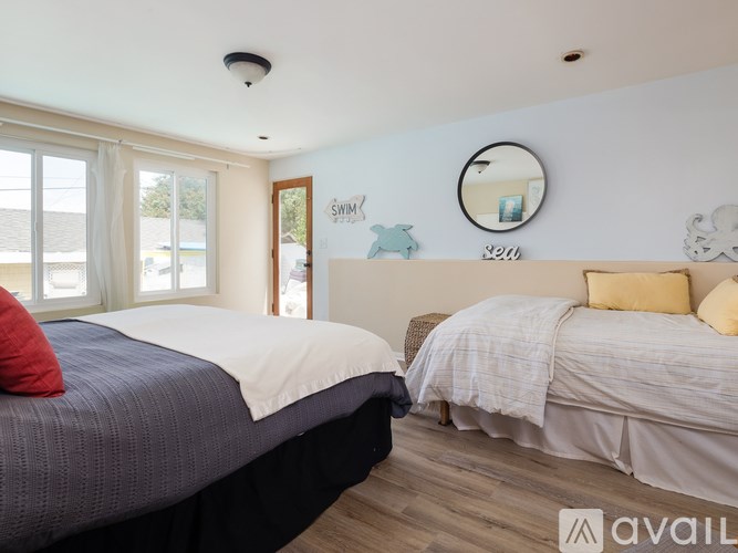 A bedroom with two beds and a mirror on the wall.