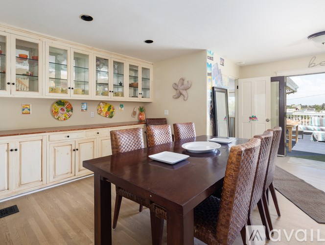 A dining room with a wooden table and chairs.