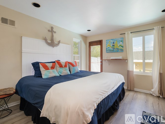 A bedroom with a large bed and a painting on the wall.