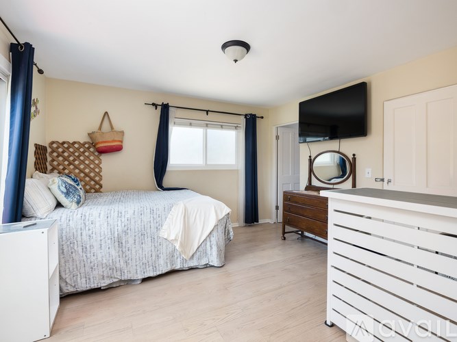 A bedroom with a bed, a dresser, and a mirror.