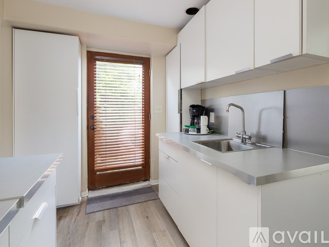A kitchen with white cabinets and a white fridge.