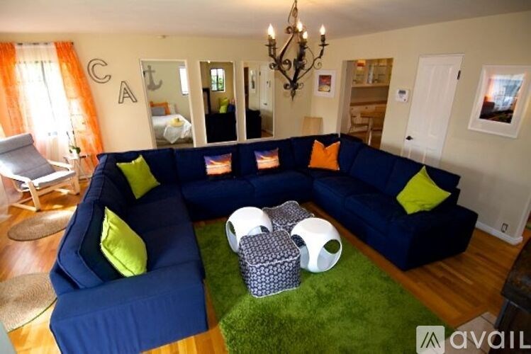 A living room with a blue couch and a chandelier.