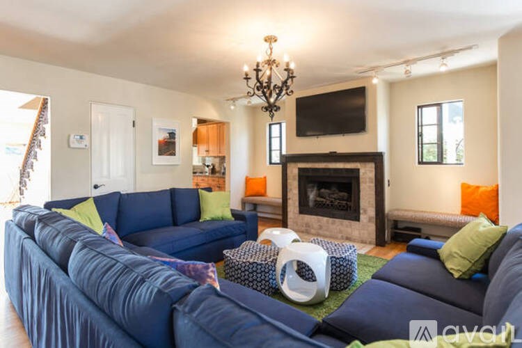 A living room with a blue couch and a fireplace.