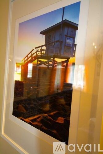 A framed picture of a tower on a beach.