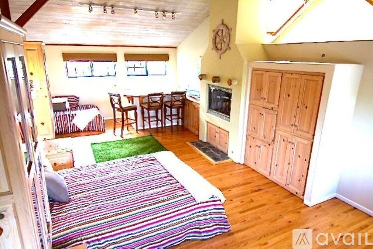 A living room with a striped rug and wooden floors.