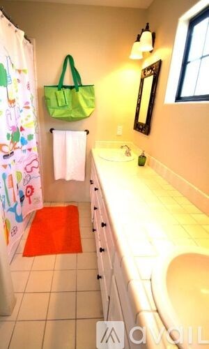 A bathroom with a green bag hanging on the wall.