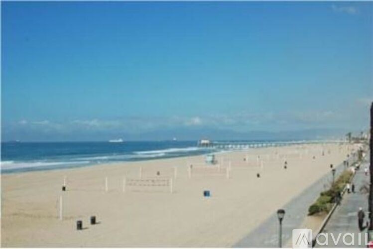 A beach with people walking on the sand and the ocean in the background.