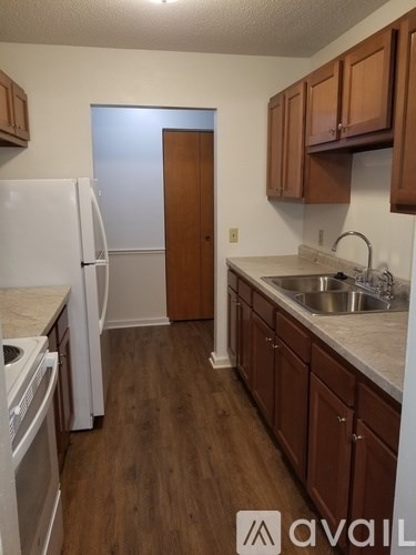 A kitchen with wooden cabinets and a white fridge.