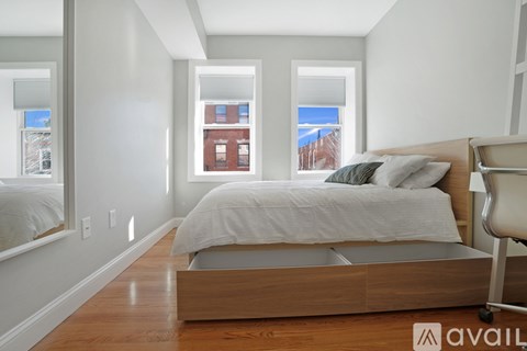 A bedroom with a large bed and a window overlooking a cityscape.